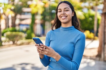 Young african american woman smiling confident using smartphone at park