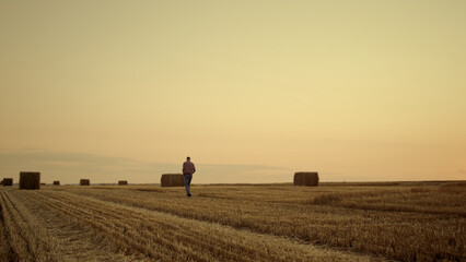 Agrarian walk haystack field at sunset countryside. Rural landscape concept