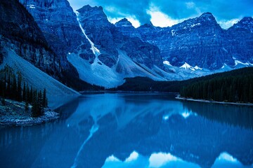 Scenic view of the lake, trees, and mountains of Banff at night