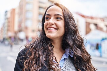 Young hispanic woman smiling confident standing at street