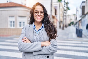 Young hispanic woman executive smiling confident standing with arms crossed gesture at street