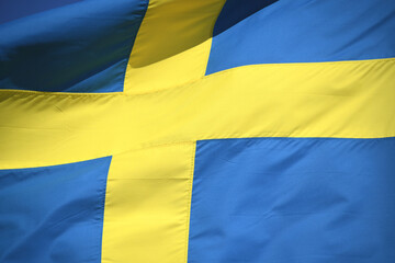 Die Nationalfahne von Schweden in den Faben blau und gelb weht im Wind. Die Krone ist die Währung von Schweden. 
