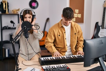 Mand and woman musicians singing song playing piano keyboard at music studio