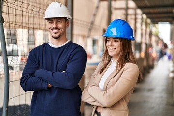 Mand and woman architects smiling confident standing with arms crossed gesture at street