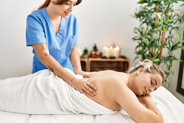 Obraz na płótnie Canvas Woman couple smiling confident having back massage at beauty center