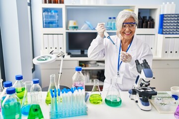 Middle age woman wearing scientist uniform working at laboratory