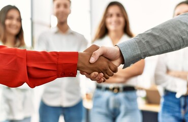Group of business workers looking partners handshake at the office.