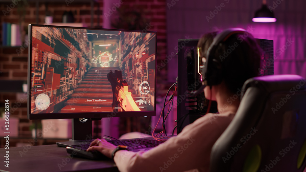 Poster over shoulder view of gamer girl using pc gaming setup relaxing playing multiplayer online action vi