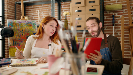 Man and woman couple using touchpad and drawing at art studio