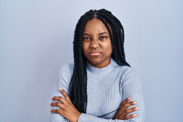 African american woman standing over blue background skeptic and nervous, disapproving expression...