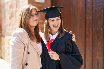 Mother and daughter hugging each other celebrating graduation at university