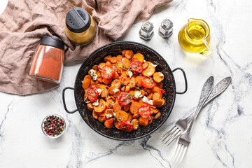 Composition with frying pan of tasty baked vegetables, oil and spices on light background
