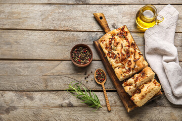 Composition with tasty Italian focaccia, jug of oil and peppercorns on wooden background