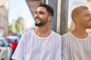 Fototapeta premium Young arab man smiling confident looking to the side at street