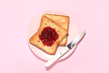 Plate of toasts with sweet jam and knife on pink background - obrazy, fototapety, plakaty