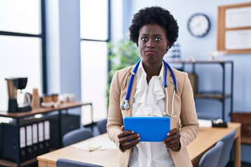 African young woman wearing doctor stethoscope skeptic and nervous, frowning upset because of problem. negative person.