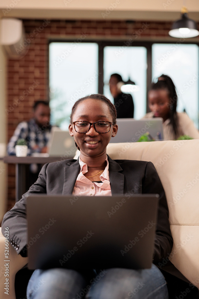 Poster female freelancer working on laptop in office, browsing internet to find research data and informati