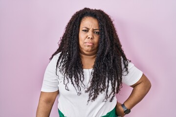 Plus size hispanic woman standing over pink background depressed and worry for distress, crying angry and afraid. sad expression.