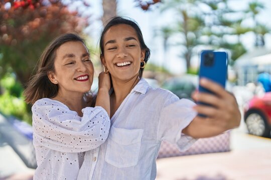 Two women mother and daughter make selfie by smartphone at park