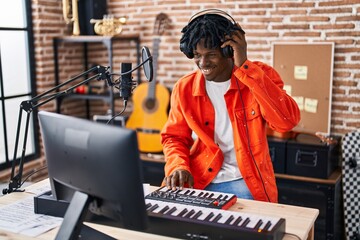 African american man musician playing piano keyboard at music studio