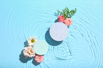Beautiful composition with decorative stands and flowers in water against blue background