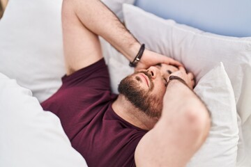 Fototapeta na wymiar Young hispanic man suffering insomnia lying on bed at bedroom