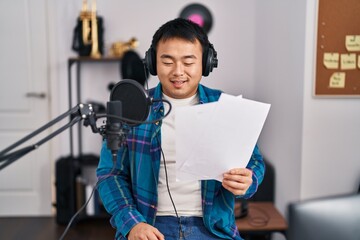 Young chinese man singer singing song at music studio