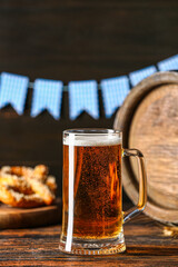 Mug of fresh beer on table against dark background, closeup. Oktoberfest celebration