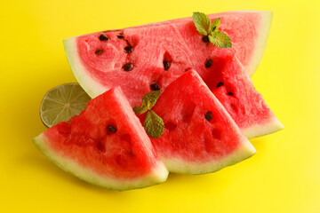 Slices of watermelon with mint on yellow background