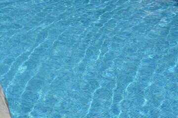 Clear refreshing water in swimming pool on sunny day, closeup