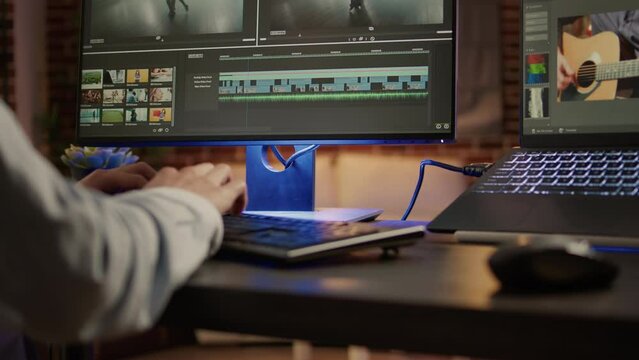 Multimedia artist editing movie footage on post production software, using visual effects on montage for cinematic look. Color correction and grading on video. Handheld shot. Close up.