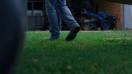 Closeup aviator legs walking around plane. Pilot going to airplane on grass.