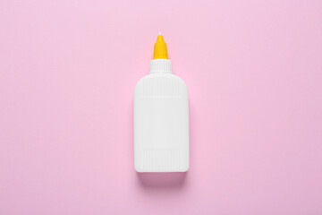 Bottle of glue on pink background, top view