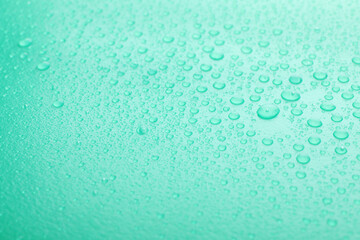 Water drops on turquoise background, closeup view