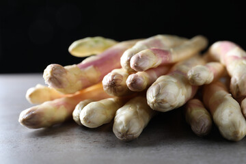 Pile of fresh white asparagus on grey table, closeup
