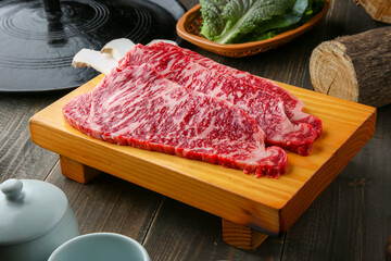 Beef chuck flap tail and side dishes in the background 나무배경에 소고기 살치살과 밑반찬들