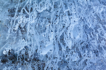 Texture of winter ice on a stone cliff. Blue natural ice background