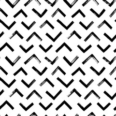 Vector seamless pattern with triangular lines. Ethnic or tribal chevron ornament zig zag and triangular brush strokes. Geometric textured grunge pattern for wallpaper, fabric print, wrapping paper. 