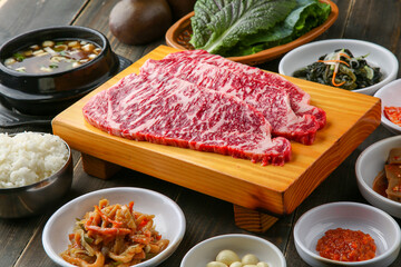 Beef chuck flap tail and side dishes in the background 나무배경에 소고기 살치살과 밑반찬들