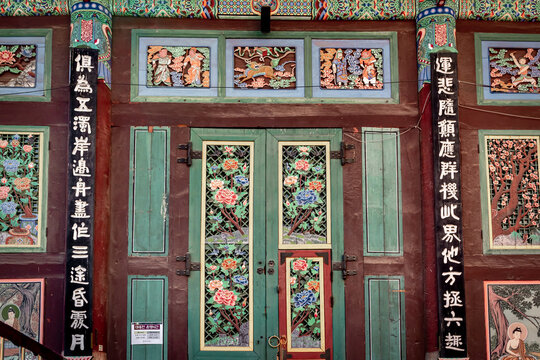 Colorful traditional Korean design painted wood artwork wall at Jogyesa Buddhist temple in Seoul South Korea