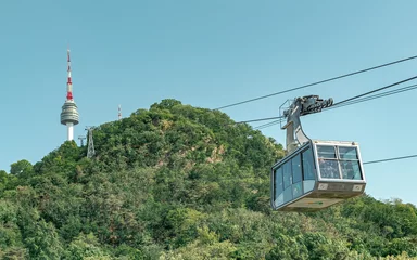 Gordijnen Green forest on a mountain and cable car view of Namsan Seoul tower park in Seoul South Korea © Jacki