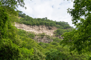 trees framing mountains, huentitan canyon in guadalajara, mountains and trees, green vegetation and sky with clouds, mexico