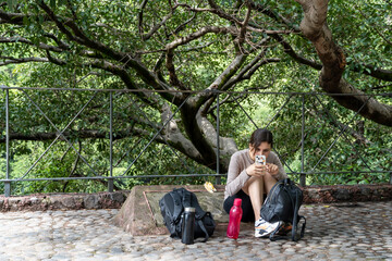 young woman taking photo with her cell phone in a ravine, vegetation, trees, stone floor, guadalajara