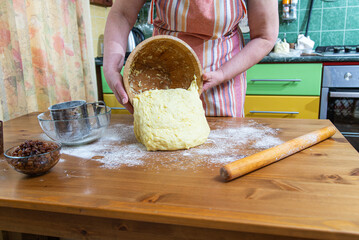 Dough that has doubled in size. The woman takes out the finished dough from a wooden bowl. dough...