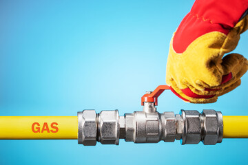 Opening or closing the gas pipeline gate. Male hand in yellow glove  opens or closes gas valve on...