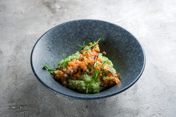 risotto with seafood, sliced salmon on grey table