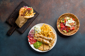souvlaki with chicken vegetables and pita, greek salad with feta and pita gyros with beef patty and...