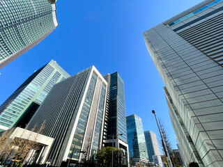 Fototapeta na wymiar 気持ちの良い青空のなか、たくさんのビルが立ち並ぶオフィス街