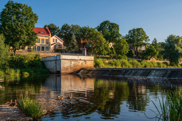 Fototapeta na wymiar View of the embankment and the dam on the Pskova River on a sunny summer day, Pskov, Russia