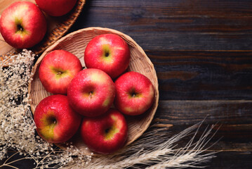 Red apple fruit in basket on wooden background, Table top view